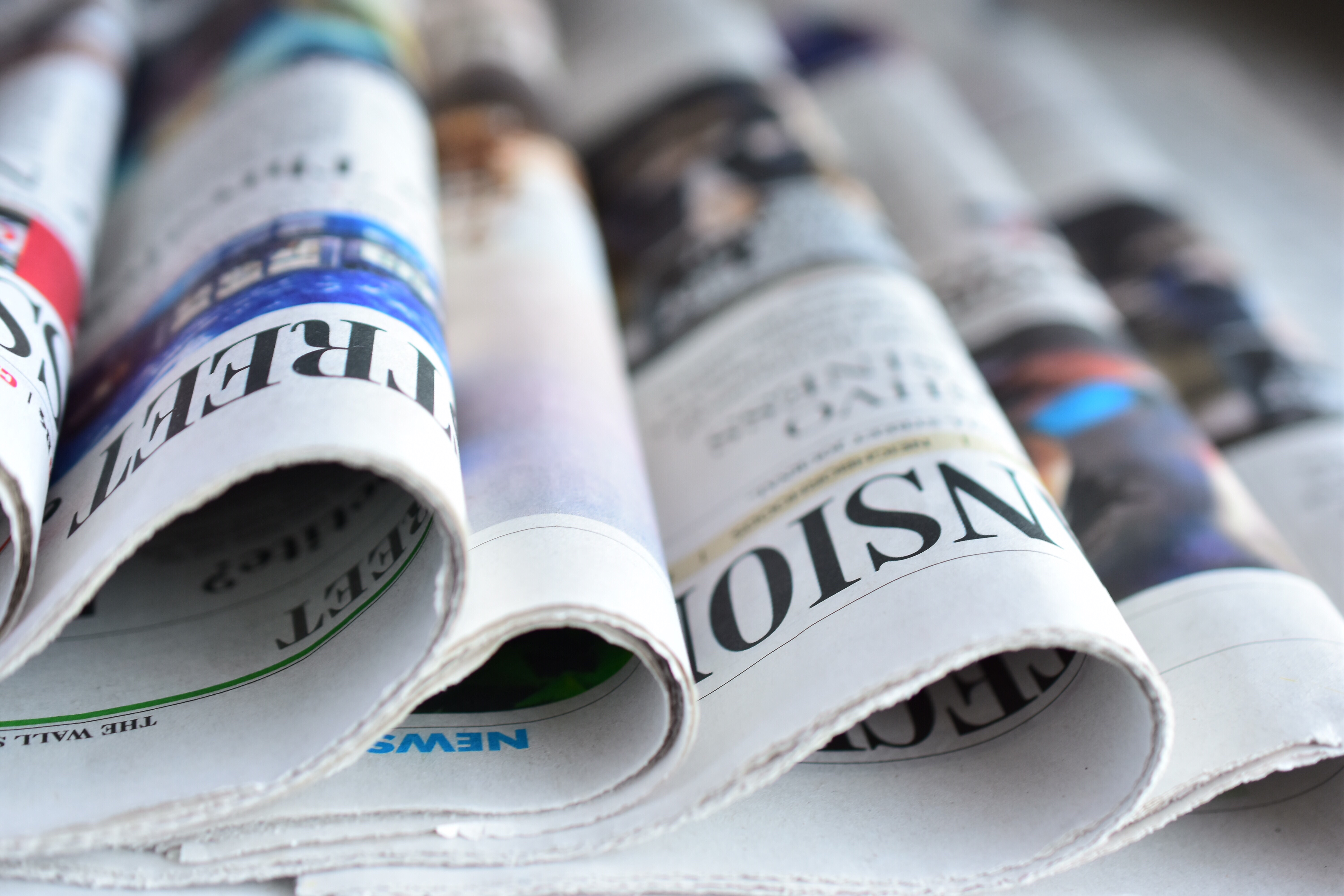 Reader with local newspaper on desk